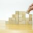 Wooden blocks stacked in ascending steps, symbolising the ADKAR model's five sequential building blocks